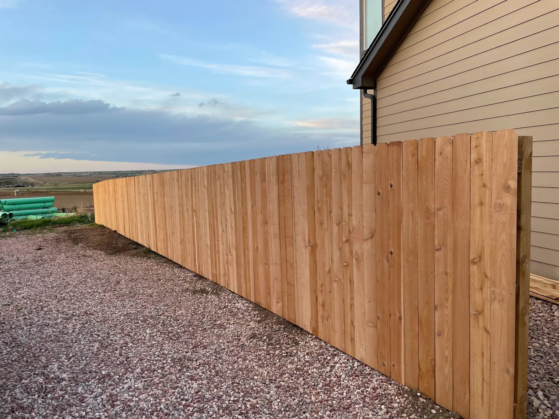 Long cedar privacy fence bordering an open residential property