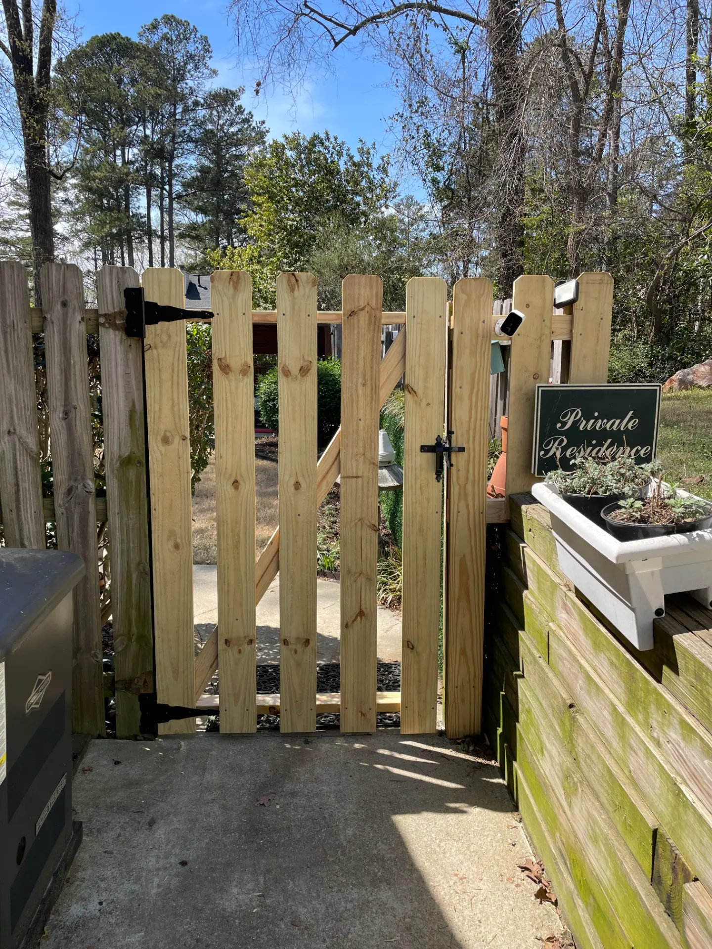 Natural wood walk gate with black hinges and latch at a private residence