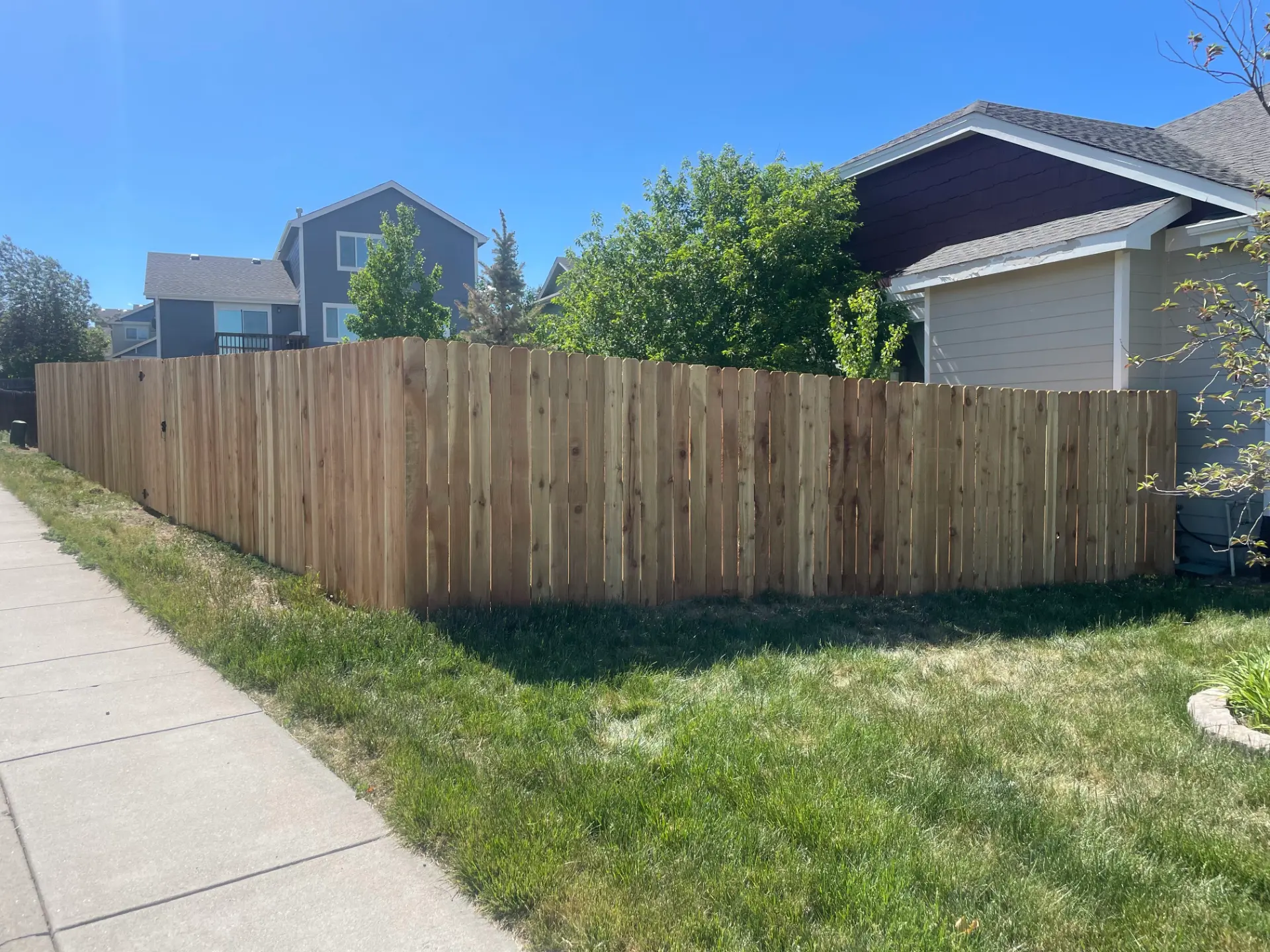 New wood privacy fence following the corner of a residential yard
