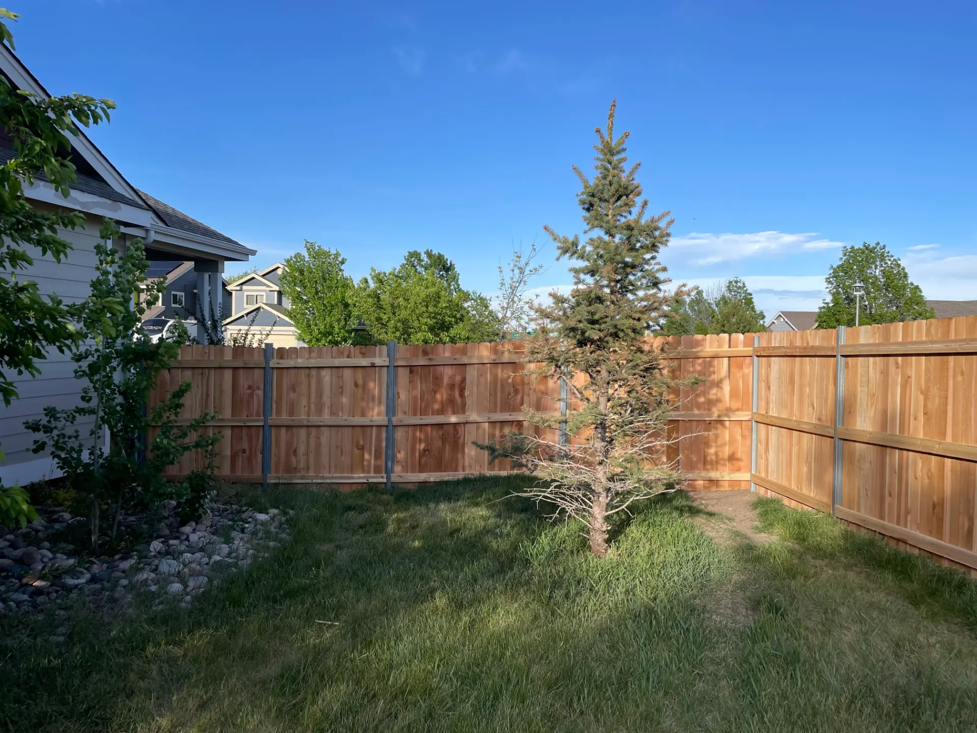 Cedar privacy fence built with steel posts around a residential yard