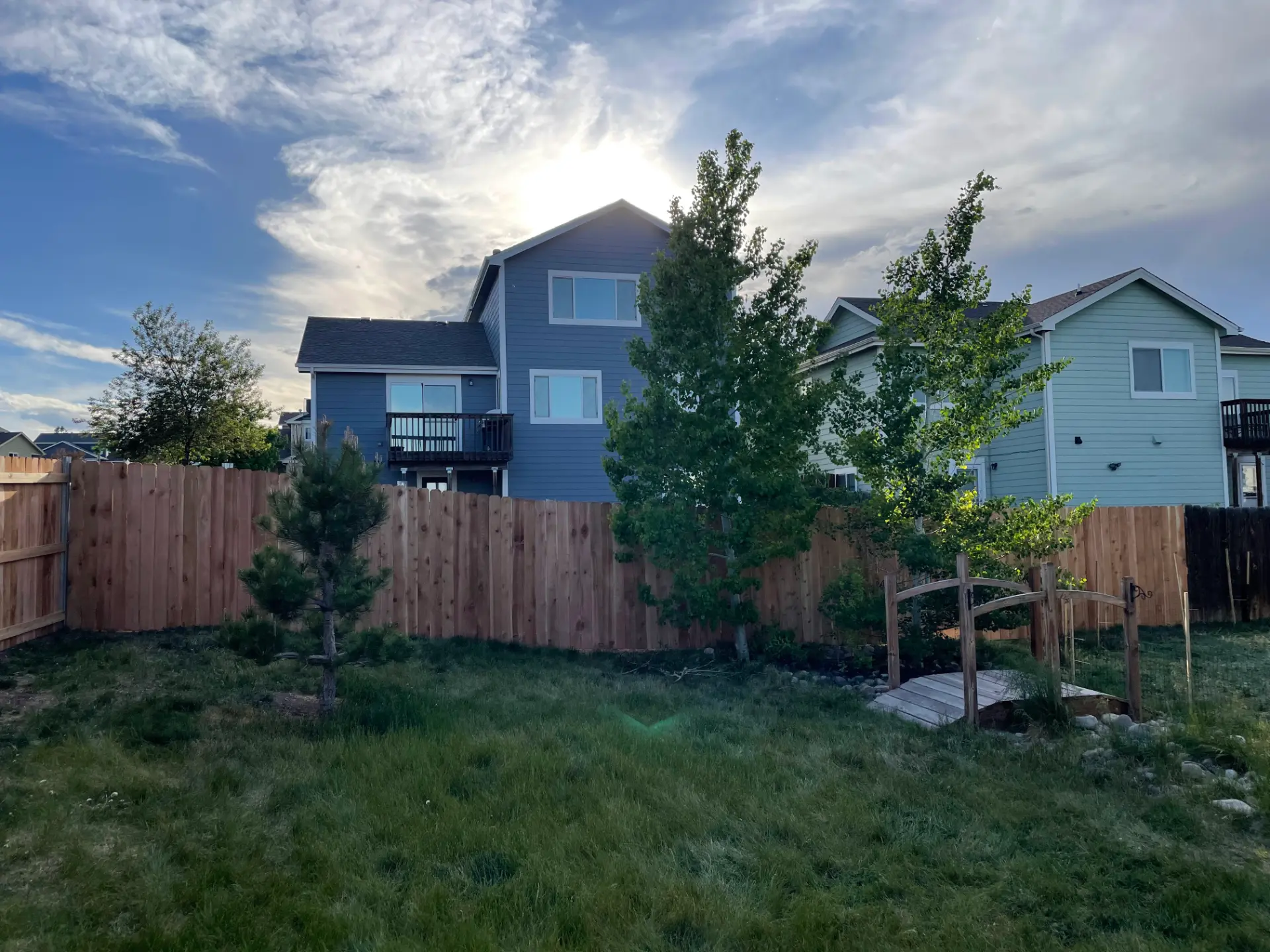 Cedar privacy fence installed around a landscaped residential backyard