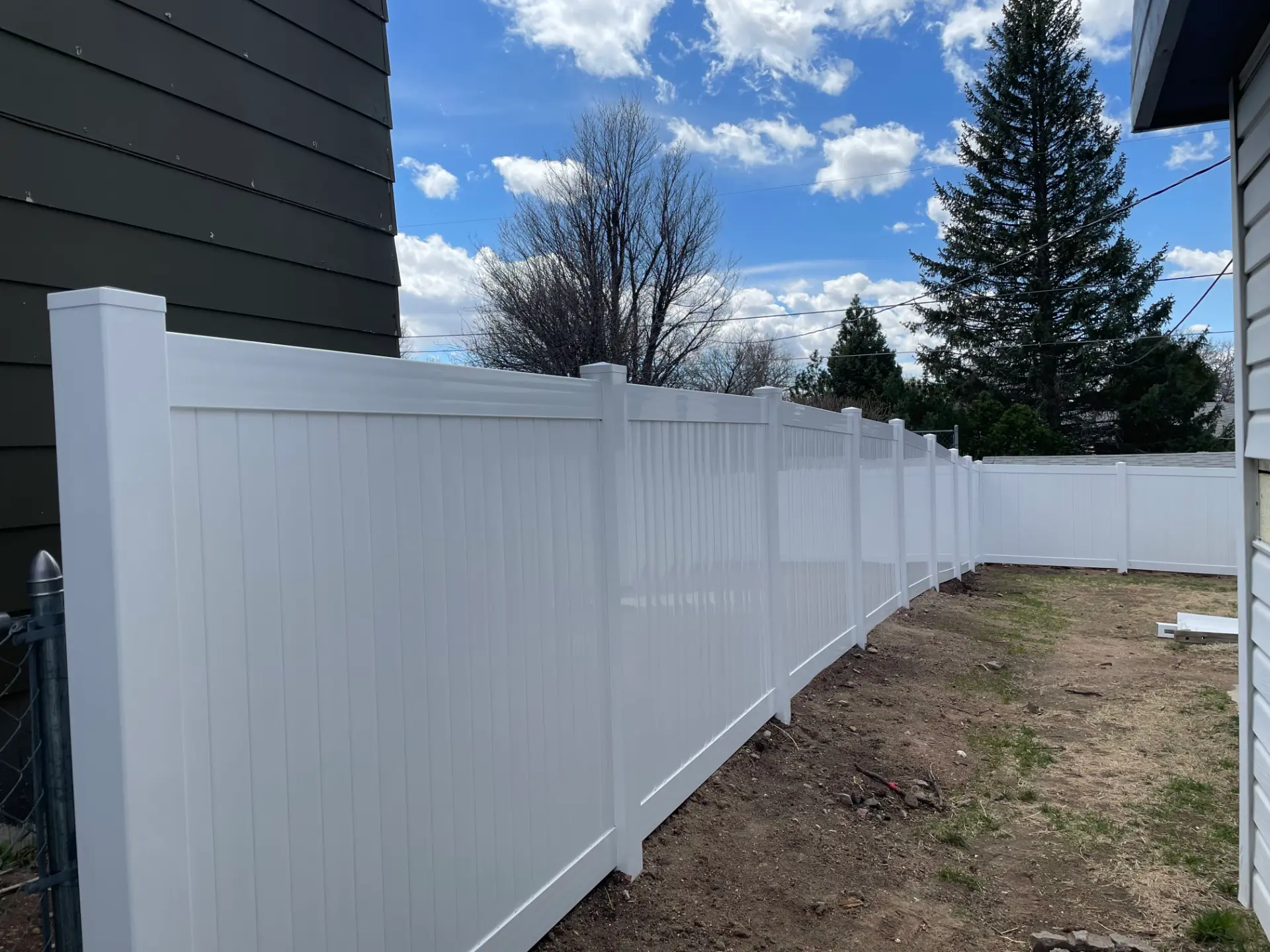 New white vinyl privacy fence enclosing a residential side yard